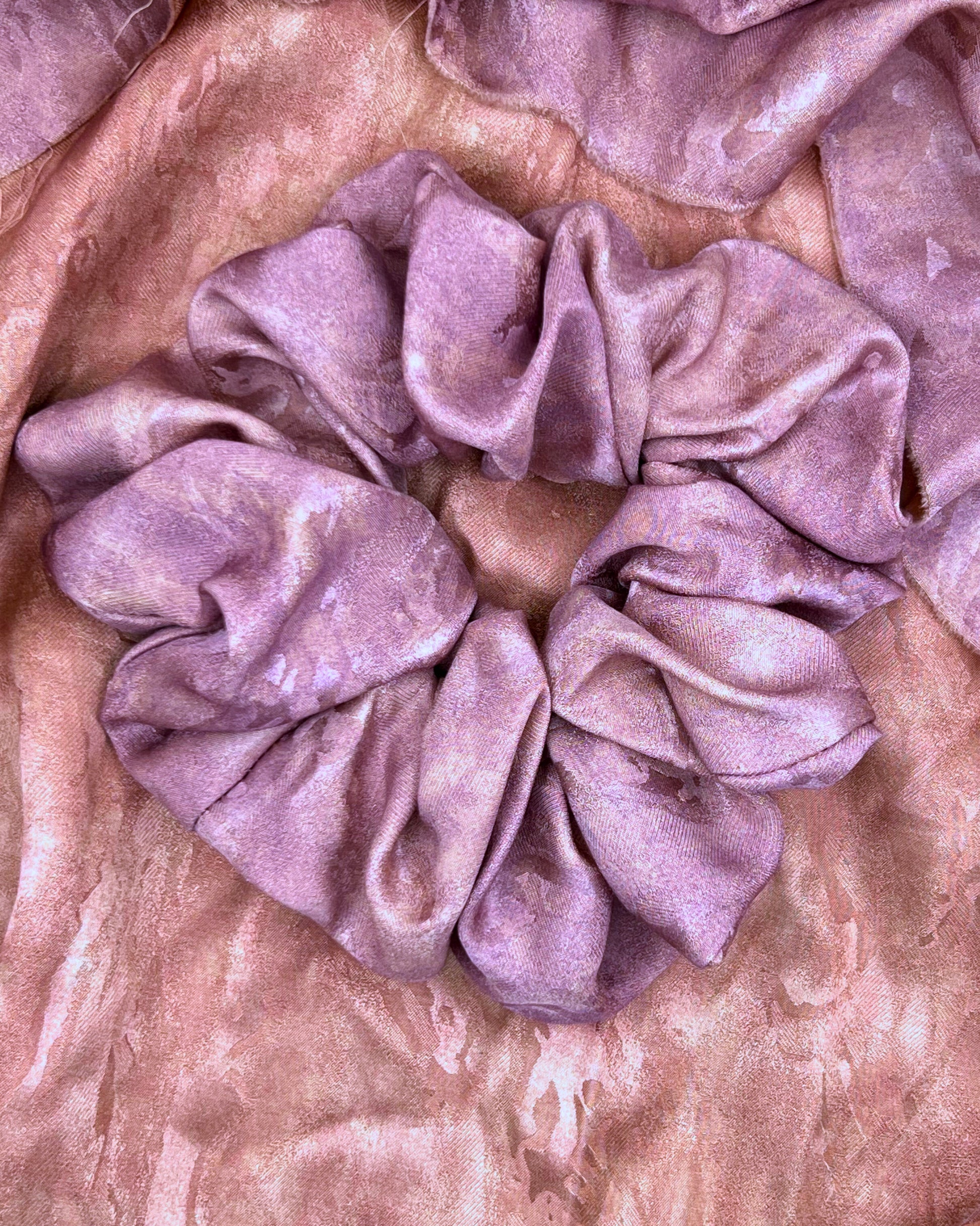 Purple Pink handmade rose aromatic scented mulberry silk scrunchie on a pink textured  rose aromatic scented mulberry silk fabric background