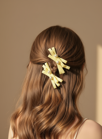 Woman with wavy hair wearing Two yellow hair clips with layered  bows pearl accents against a beige background