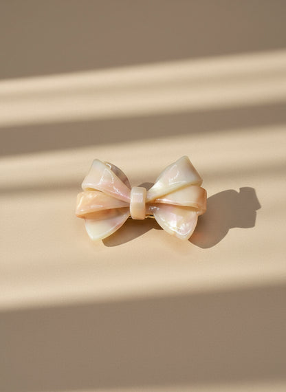 Blush ombré aztec bow hair clip on a beige background, only at petite murmure