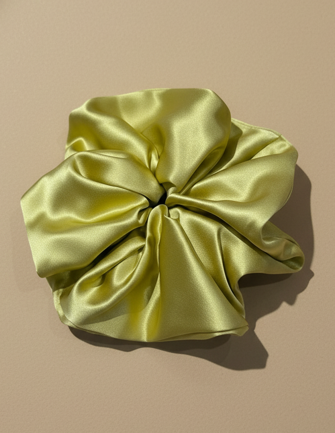 Light champagne mustard handcrafted 30mm mulberry silk scrunchie on a beige background