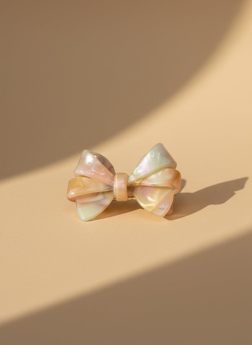 Blush ombré aztec bow hair clip with a pearl-like finish on a beige background