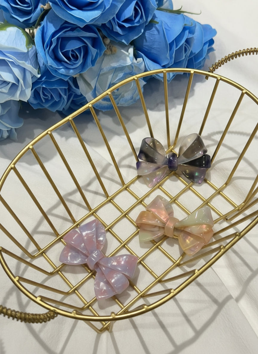 Gold wire bowl with decorative bows on a white surface with blue flowers in the background 3different  ombré aztec bows hair clip