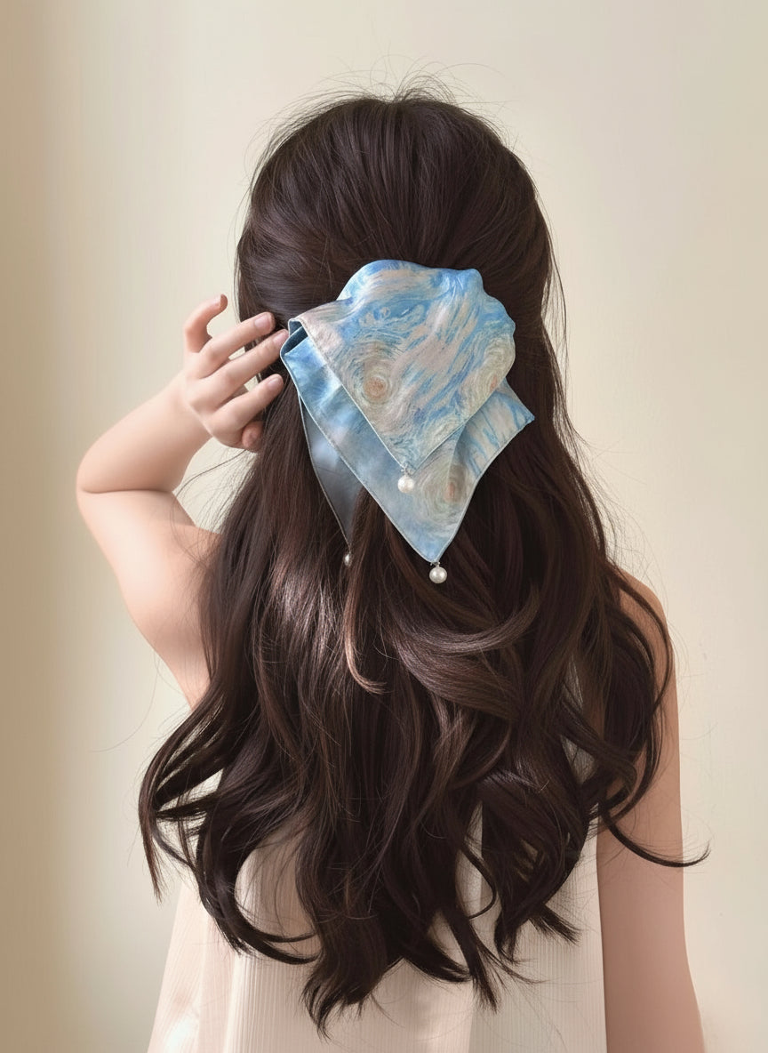a model with long hair wearing a Blue and white tie-dye satin square handkerchief scrunchie with pearl detail  against a neutral white background, only at petitemurmure.com 