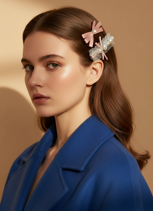Woman with pink hair clips with pink ribbons, organza and pearls in her hair against a beige background