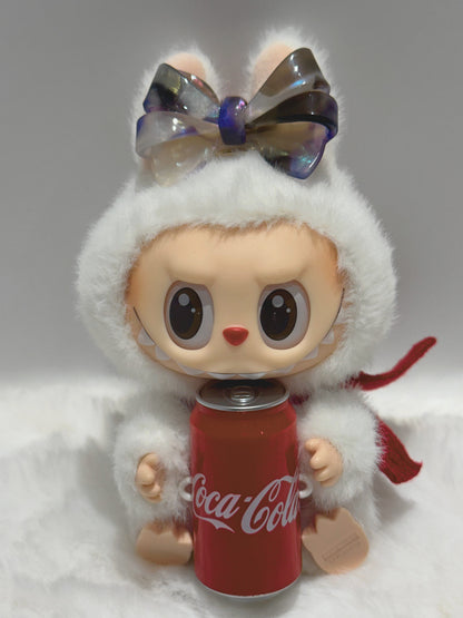 La BuBu  with Blush, purple, and smoky ombré aztec bow hair clip , holding a Coca-Cola can on a gray background