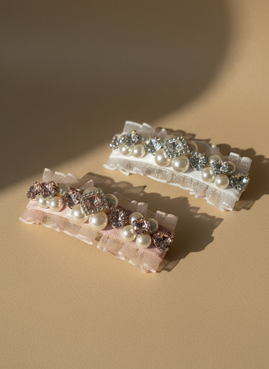 Pair of hair clips with Swarovski crystals and pearls embellished and silky organza on a beige background