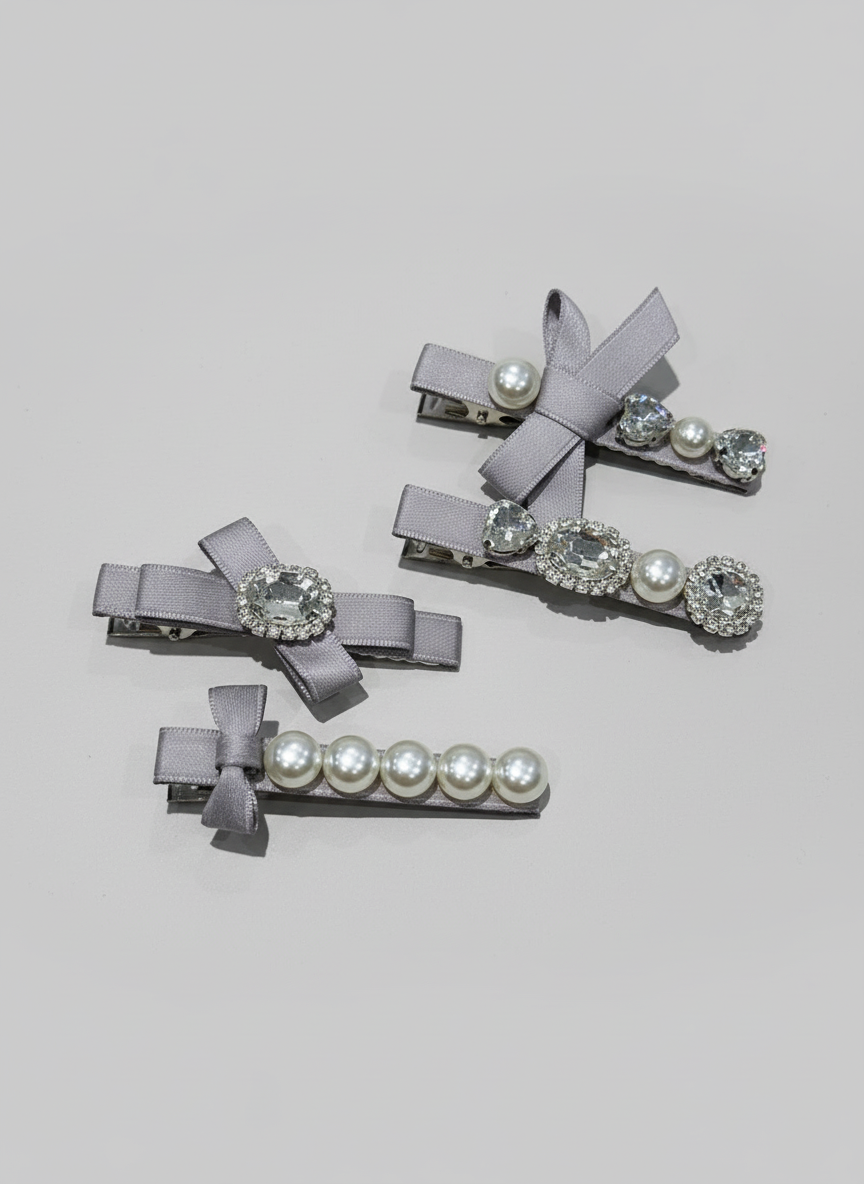 Set of gray hair clips with decorative elements such as Pink bow hair clip with gray bow hair clip with gray ribbons pearls and Swarovski crystals on a light gray background