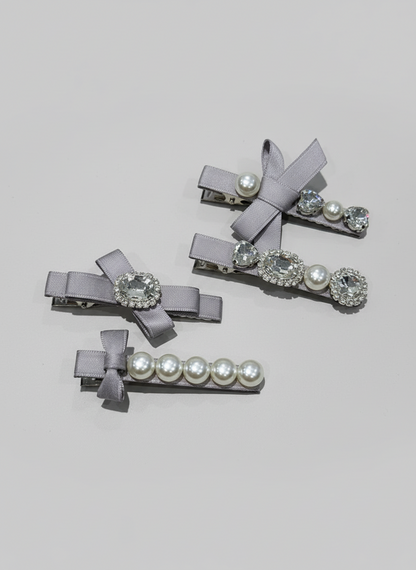 Set of gray hair clips with decorative elements such as Pink bow hair clip with gray bow hair clip with gray ribbons pearls and Swarovski crystals on a light gray background