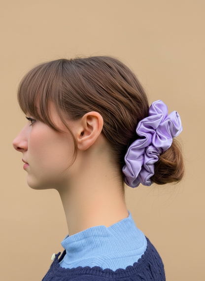 Woman with a Lilac/ Lavender handcrafted 30mm mulberry silk scrunchie in her hair against a beige background