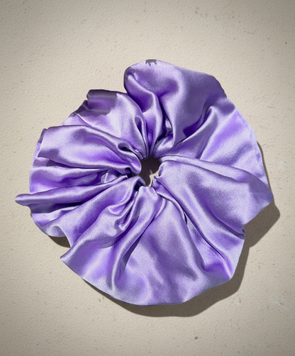 Lilac/ Lavender  handcrafted 30mm mulberry silk scrunchie on a beige background