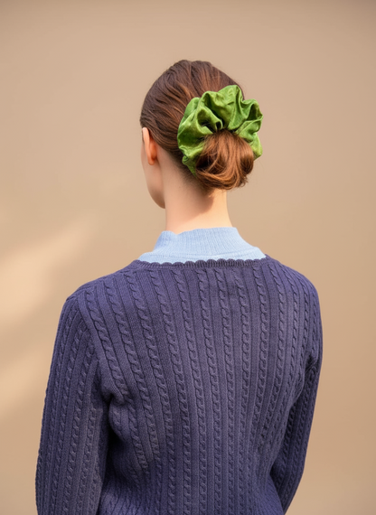 Person wearing a green Handmade Green Tea Scented Mulberry Silk Scrunchies  in their hair against a beige background