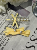 Yellow hair bows with pearl details and organza on a newspaper background