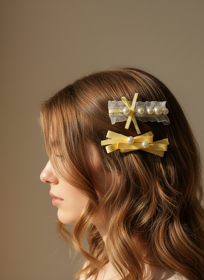 Woman with wavy hair wearing yellow hair ribbon clips with pearls and organza against a neutral background