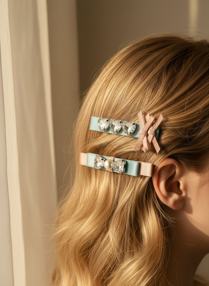 Person with Two decorative hair clips with pink and blue ribbons and pearl and Swarovski crystals in her blonde hair against a neutral background