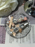 Decorative hair clips with ribbon. pearls and Swarovski crystals embellished hair clips on a textured crystal surface