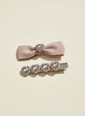 Pink bow hair clip with pink bow hair clip with pink ribbons and heart shape Swarovski crystals elements on a beige background
