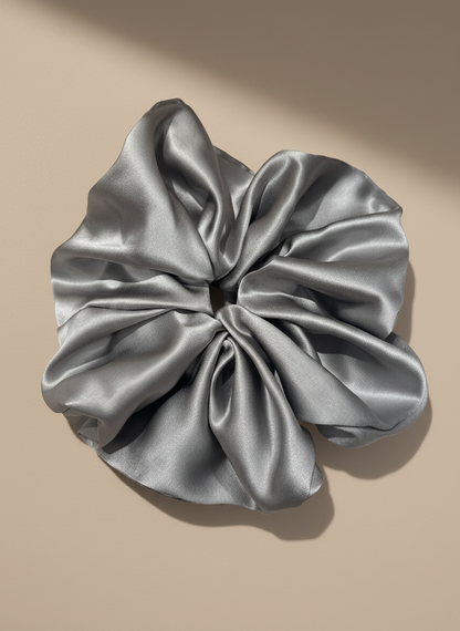 Silver Gray  handcrafted 30mm mulberry silk scrunchie on a beige background