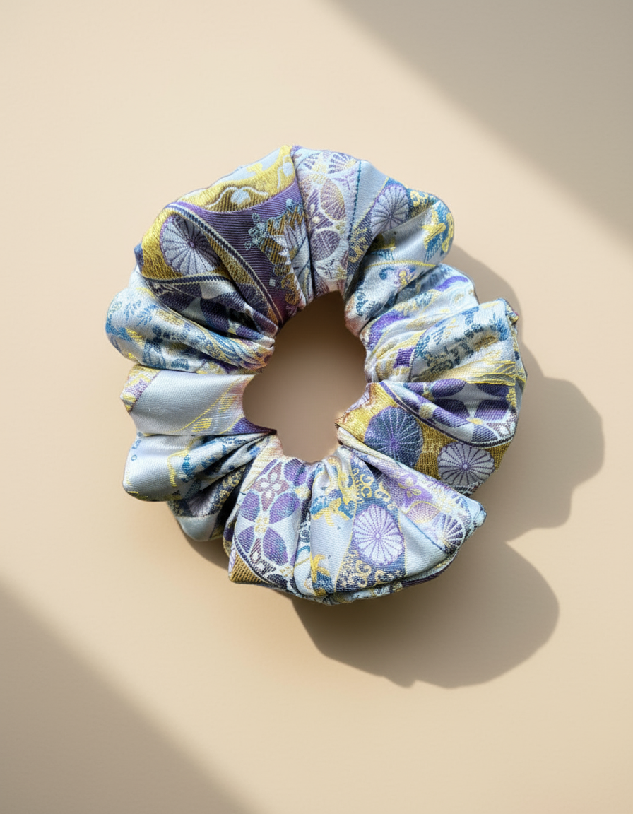 Exclusive Song brocade mulberry silk scrunchie with peony aromatic scent, infused with gold thread. Phoenix patterned scrunchie on a beige background
