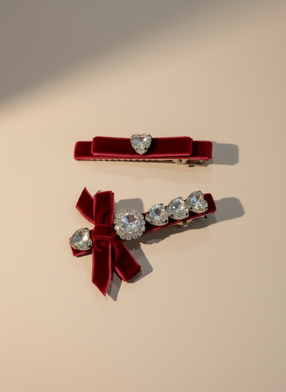 Two red velvet hair clips with Swarovski crystal stones on a warm beige background
