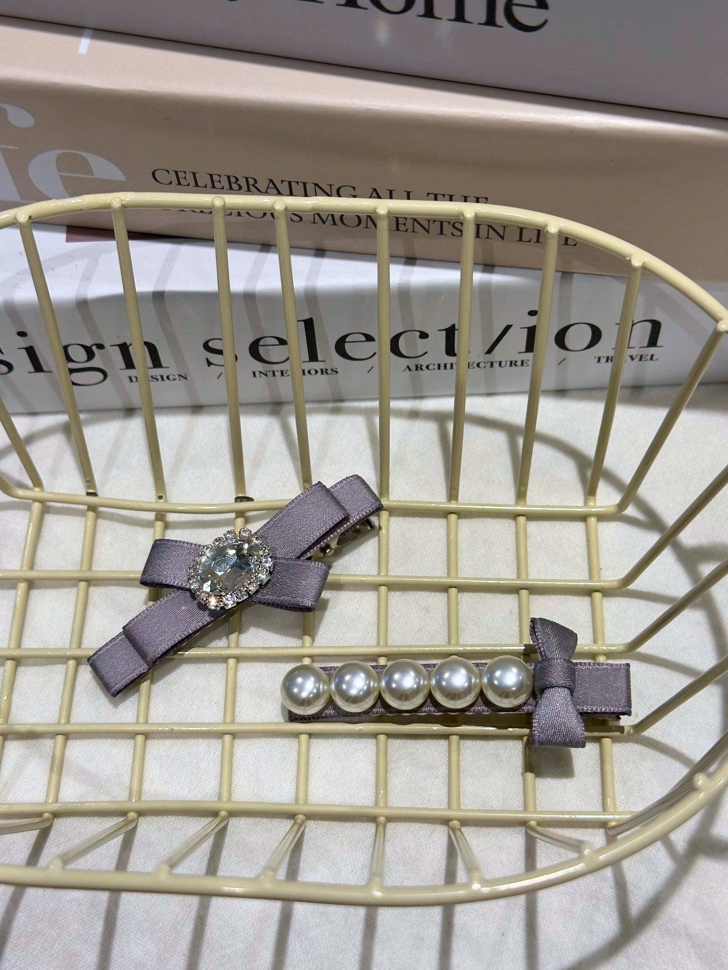 Two hair clips with Set of ribbon bow hair clips with Swarovski crystals and pearls  on a wire surface.