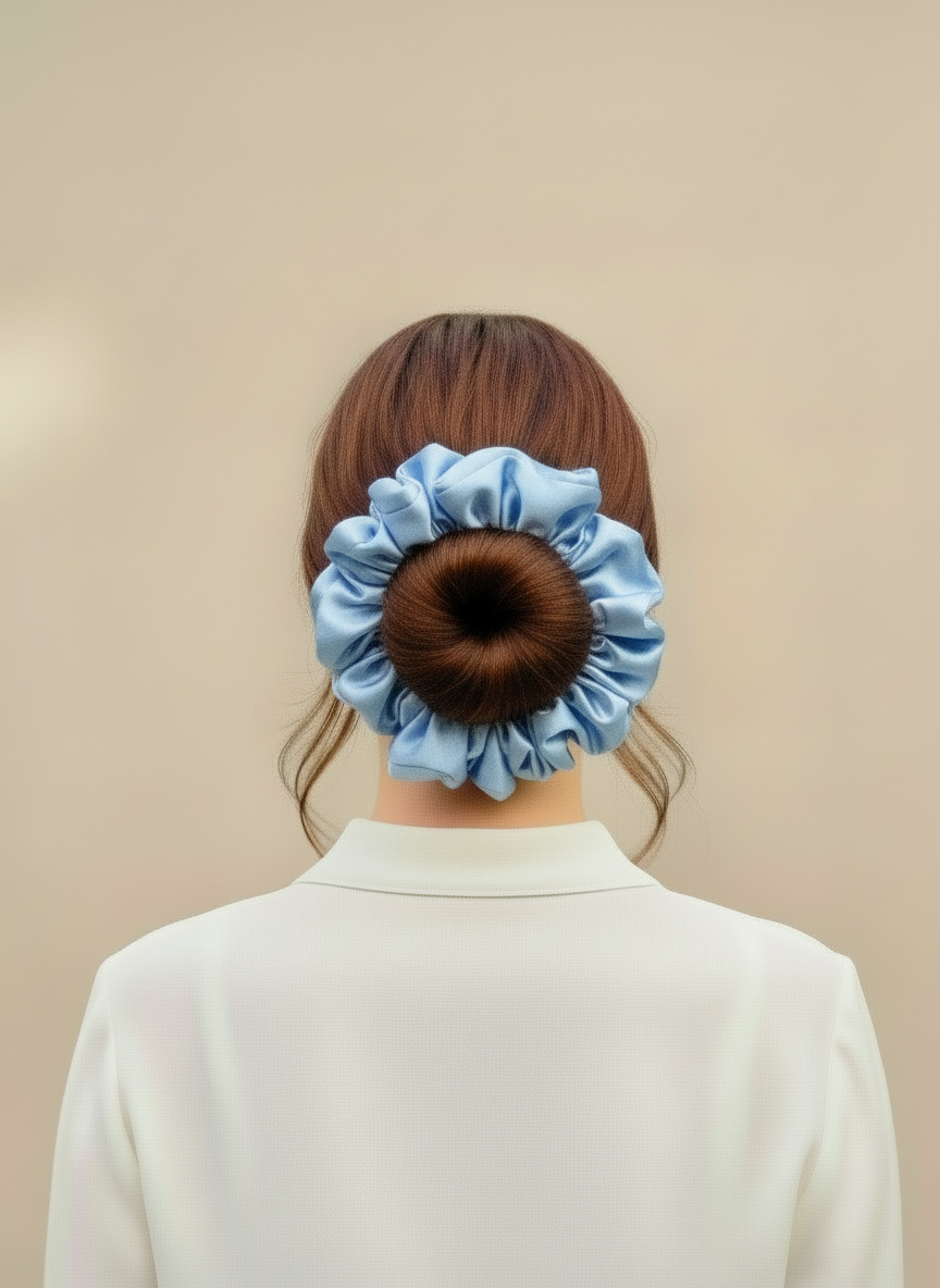 Person wearing a Blue handcrafted 30mm mulberry silk scrunchie in their hair against a beige background
