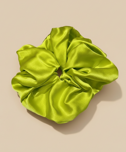 Neon Green handcrafted 30mm mulberry silk scrunchie on a beige background