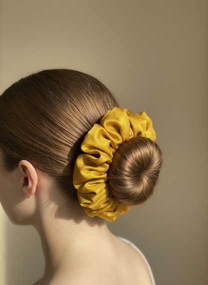 Gold Handmade Green Tea Scented Mulberry Silk Scrunchies  on a bun against a beige background