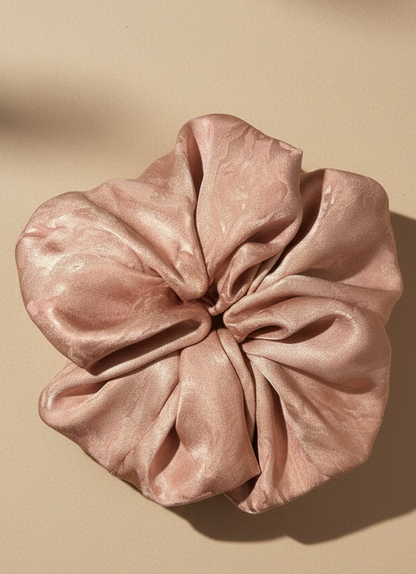 Pink handmade mulberry silk scrunchie with peony aroma scent on a beige background