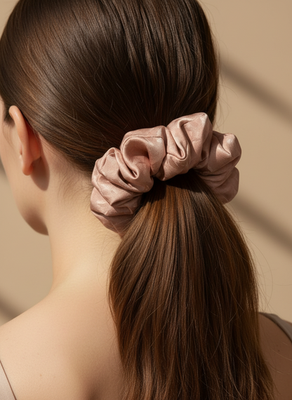 Woman with a high ponytail held by a pink Pink handmade mulberry silk scrunchie with peony aroma scent against a beige background