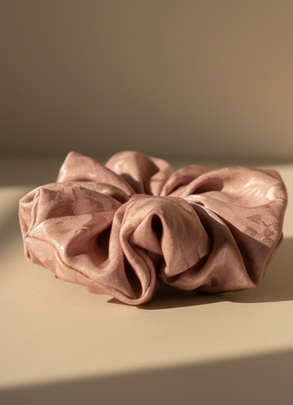 Pink handmade rose aromatic scented mulberry silk scrunchie on a beige surface with a neutral background