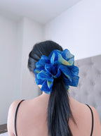 Female model with a a large blue organza scrunchies in her hair that inspired by Van Gogh's  the Starry Night, only at Petite 
Murmure,against a neutral background