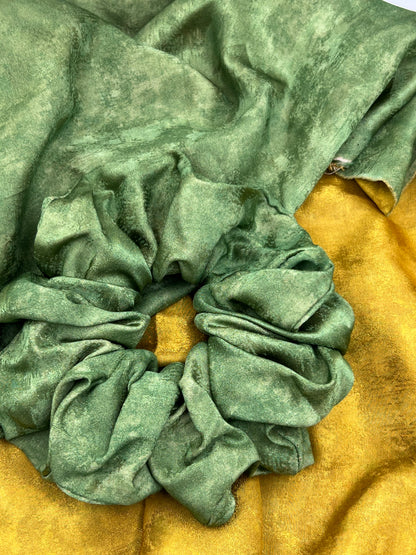 Green Handmade Green Tea Scented Mulberry Silk Scrunchies  on a yellow fabric background