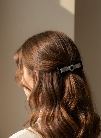 Woman with long brown hair wearing a black hair clip with heart shape Swarovski crystal entered hair clip against a neutral background