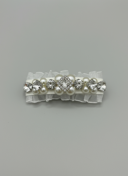 a white hair clip with Swarovski crystals and pearls embellished and silky organza  on a gray background. Only at Petite Murmure