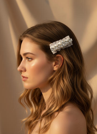 Woman with long hair wearing a hair clip with Swarovski crystals and pearls embellished and silky organza p against a beige background.only at Petite Murmure