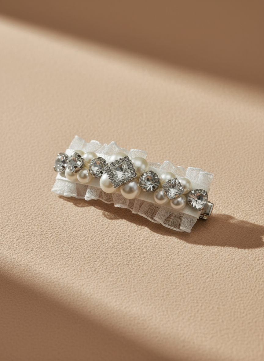 A hair clip with Swarovski crystals and pearls embellished and silky organza  on a beige background. Only at Petite Murmure