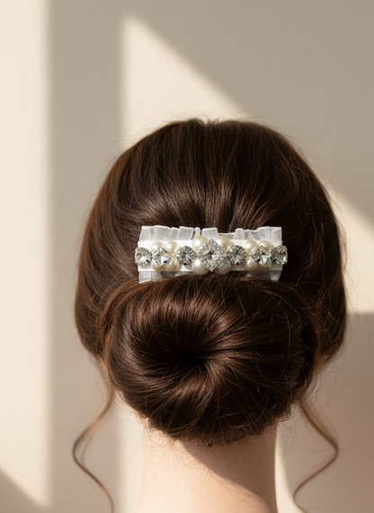 Hair bun with a  hair clip with Swarovski crystals and pearls embellished and silky organza  against a neutral background