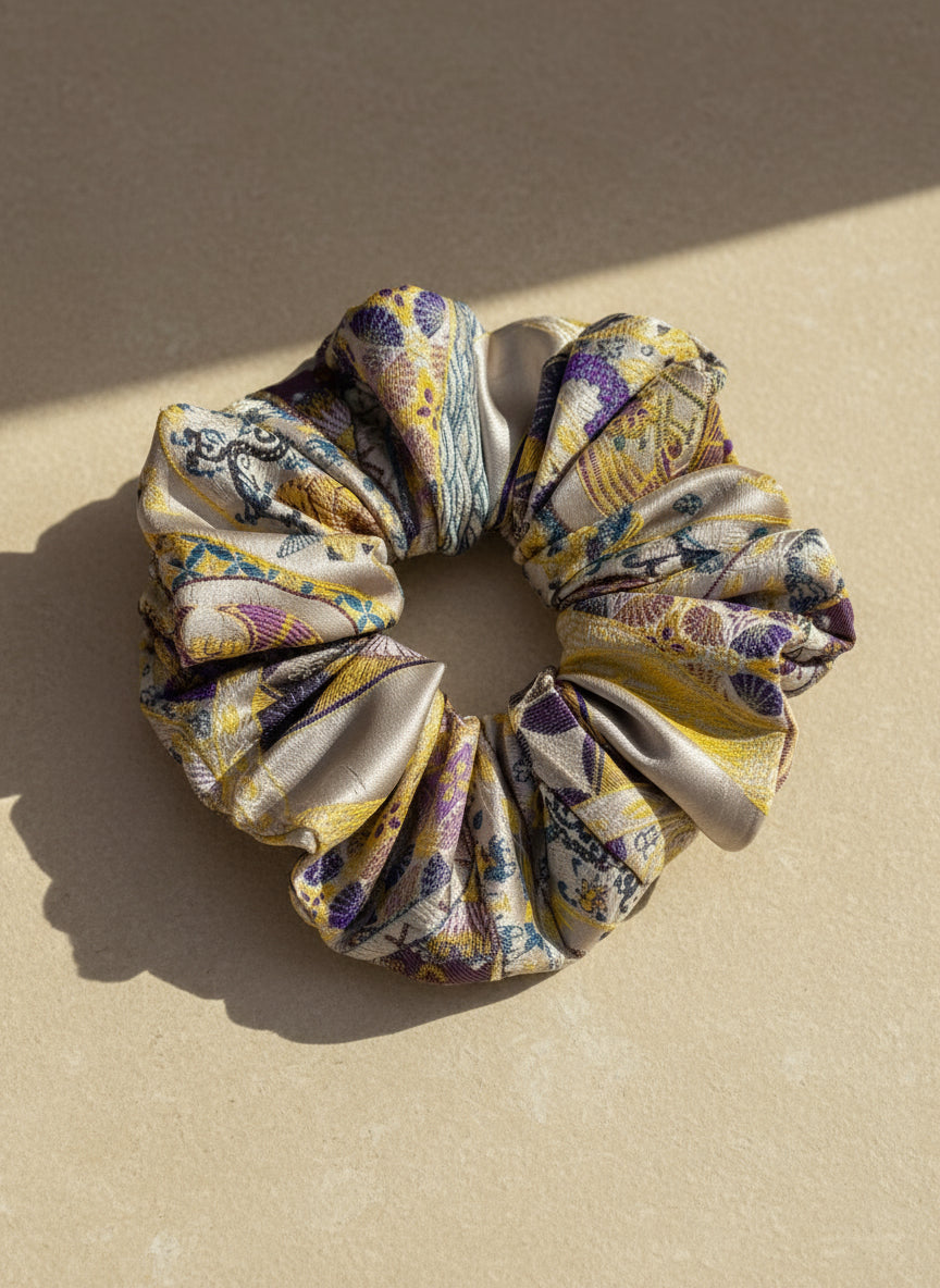 Exclusive Song brocade mulberry silk scrunchie with peony aromatic scent, infused with gold thread. Phoenix patterned scrunchie on a beige background