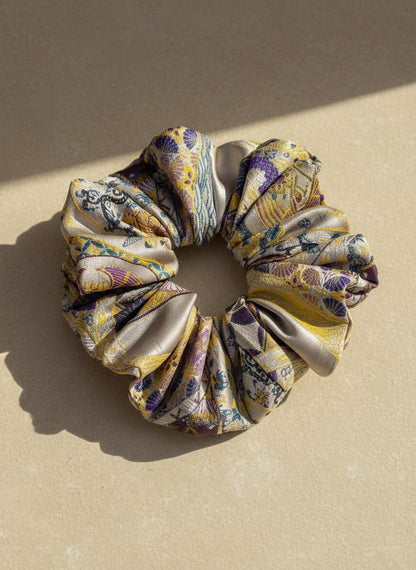 Exclusive Song brocade mulberry silk scrunchie with peony aromatic scent, infused with gold thread. Phoenix patterned scrunchie on a beige background