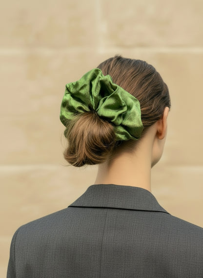 Person wearing a green Handmade Green Tea Scented Mulberry Silk Scrunchies  in their hair against a beige background